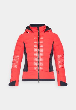 Casaco acolchoado em vermelho brilhante com um detalhe em azul marinho, apresentando fecho zip na frente, capuz e bolsos com zíper; textura brilhante no peito e nas mangas.