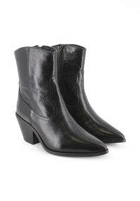 Botas de tobillo de cuero negro con punta afilada y tacón apilado. Presentan una textura suave y cierre de cremallera en el lateral.