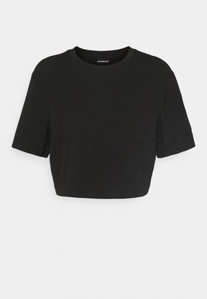 T-shirt noir raccourci en tissu doux, avec manches courtes, col rond et petite poche poitrine. Design simple et sans coutures.