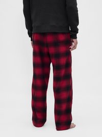 Rdeče-črne karirane flanelske hlače z ohlapnim krojem in elastičnim pasom, kombinirane s črnim dolgočasnim topom s teksturo.