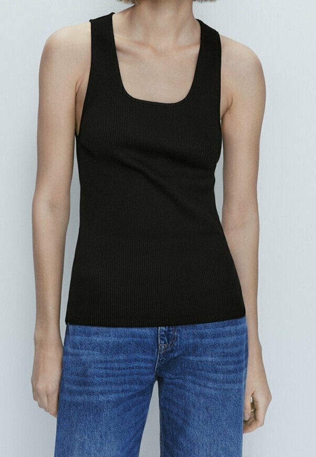 Débardeur noir côtelé avec un décolleté carré. La coupe ajustée met en valeur la silhouette. Associé à un jean en denim bleu.