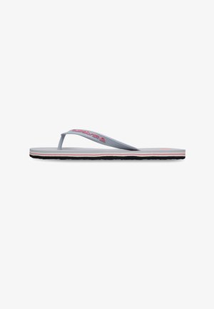 Grijze slippers met rood "Quiksilver" logo op de band, gelaagde zool met grijze, rode, witte en zwarte strepen, plat ontwerp, zijaanzicht.