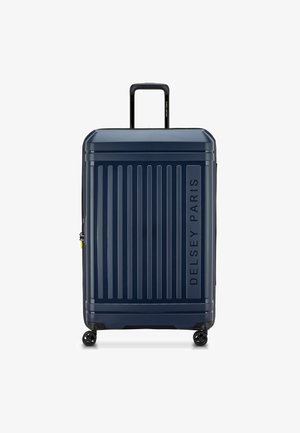 Valigia rigida blu navy con scanalature verticali, manico telescopico singolo, quattro ruote e logo impresso "Delsey Paris".