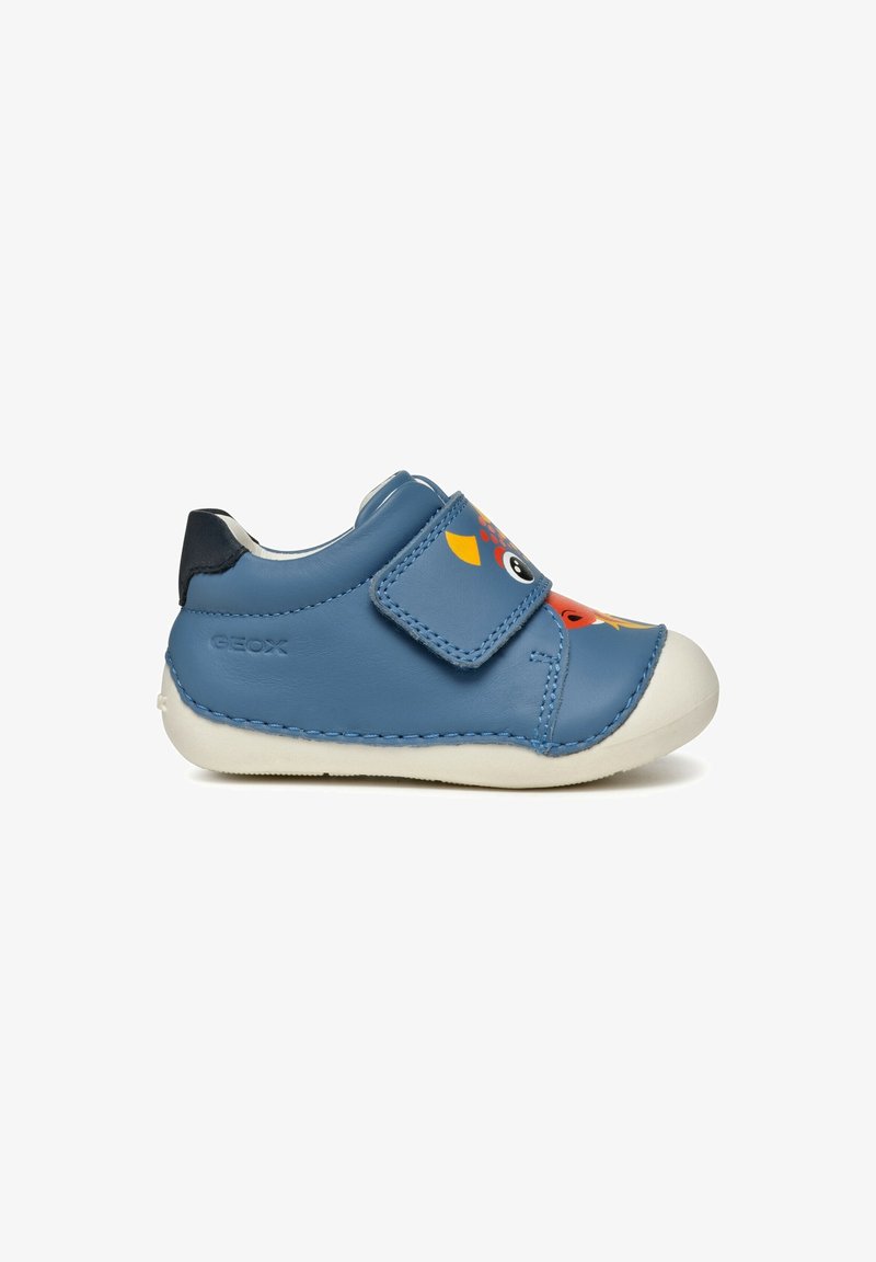 Chaussure en cuir bleue avec une sangle en velcro, présentant un design coloré d'animal sur le bout, semelle en caoutchouc blanche et accent de talon bleu foncé.