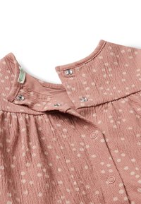 Růžové texturované šaty s bílými puntíky, disponující kulatým límcem, patentkami a nařaseným pasem pro pohodlné nošení.