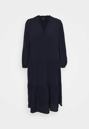 Donker marineblauwe midi-jurk met lange mouwen, een V-hals en een gelaagde geplooide rok op een effen witte achtergrond.