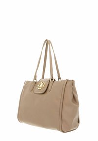 Sac à main en cuir beige au design structuré, avec deux lanières d'épaule et un emblème circulaire doré à l'avant. Texture lisse, détails minimaux.