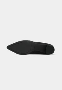 Black high-heeled shoe with a pointed toe, smooth texture, and a rubber sole. Flat heel provides stability. Minimalistic design.