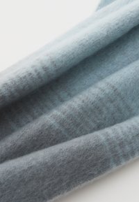 Sciarpa in lana azzurro chiaro e grigia con una texture morbida, caratterizzata da delicati motivi a gradiente e un design con bordo arrotolato.