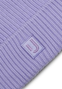 Light purple knitted beanie featuring a wide ribbed cuff and a rectangular patch with embroidered logo in a slightly darker hue.