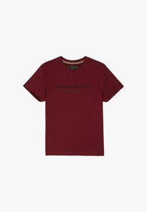 Burgundowa bawełniana koszulka z krótkim rękawem. Na przodzie znajduje się nadruk "Różnorodne Dziedzictwo" w kolorze czarnym, a także okrągły dekolt z teksturowanym wykończeniem.