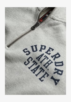 Felpa con zip grigia chiara in un mix di tessuto di cotone, dotata di una stampa blu navy che recita "SUPERDRY ATH. STATE" e di una zip in metallo.