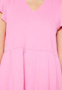 Vestido rosa de manga curta com decote em V, apresentando um corpete justo e saia franzida. Feito de um tecido leve com uma textura suave.