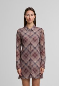 Rochie din material transparent cu mânecă lungă, având un model în carouri roz și cafeniu, cu front butonat și detalii cu margine zimțată.
