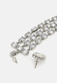 Silver-tone earring set featuring multiple clear rectangular stones in a linked design, with a push-back stud closure and flat surface accents.