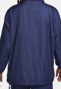 Marinblå lättviktsjacka med en slät, blank yta. Har en klassisk krage och elastiska ärmslut, designad för avslappnad användning.