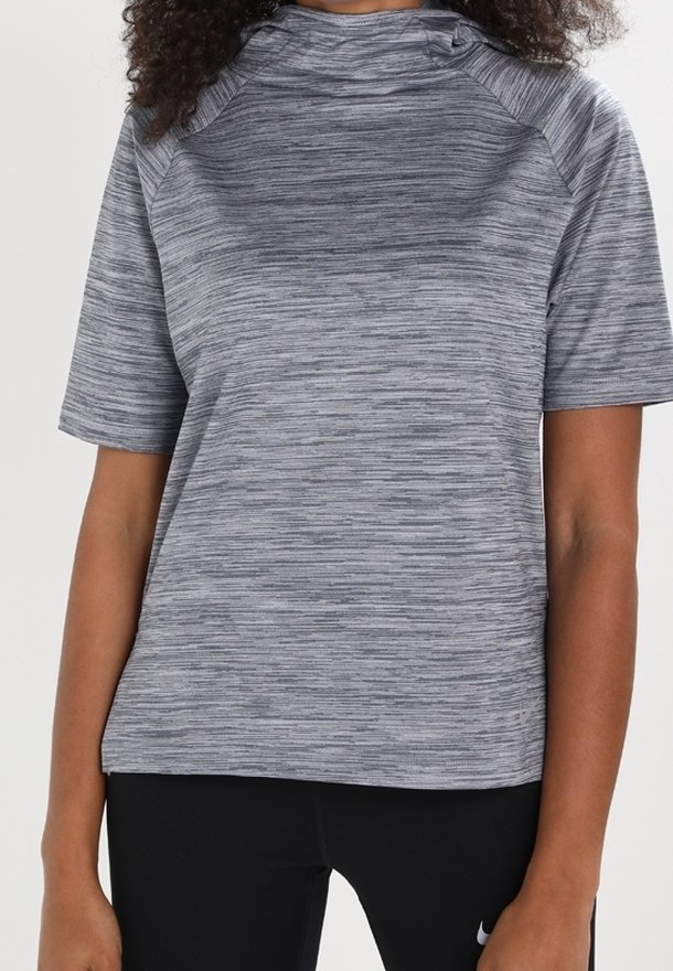 Top deportivo gris de manga corta con un patrón de rayas texturizado y cuello alto. Presenta mangas raglán y un corte relajado.