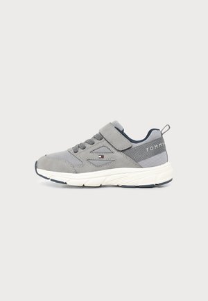 Γκρι και λευκό sneaker χαμηλής κοπής με κορδόνια και λουράκι Velcro, λεπτομέρειες από δίχτυ και το λογότυπο Tommy Hilfiger στο πλάι και στη φτέρνα.