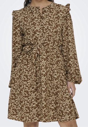 Braunes langärmliges Kleid mit weißem Blumenmuster, Rüschen-Details an den Schultern, vorne geknöpft und mit gebundenem Taillengürtel.