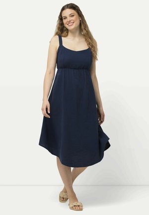 Abito senza maniche blu navy con scollatura quadrata, vita arricciata e orlo asimmetrico. Tessuto leggero con una finitura testurizzata.