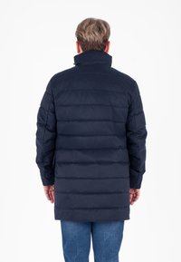 Giacca puffer blu navy con design a cuciture orizzontali, collo alto e maniche lunghe. Presenta una lunghezza media ed è realizzata in un materiale liscio e resistente.