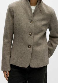 Bruine jack van een wolmix met een reverskraag, vier knopen sluiting en een gestructureerd ontwerp. Soepele textuur en een getailleerde pasvorm.