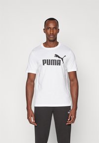 Witte katoenen T-shirt met een groot zwart "PUMA" logo en een silhouet van een poema. Korte mouwen met een ronde halslijn.