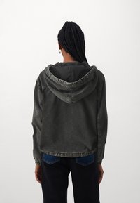Chaqueta de denim con capucha en gris oscuro, de corte relajado, que presenta una capucha con cordón, puños elásticos y un diseño ligeramente cropped.