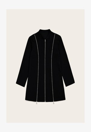 Manteau noir à manches longues, avec une fermeture éclair à l'avant et des accents en chaîne argentée. Il est doté d'un col et d'une coupe droite, avec un design minimaliste.