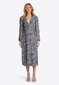 Langärmliges Kleid mit Zebra-Muster in Marineblau und Weiß, mit V-Ausschnitt und Wickeldesign. Bietet eine fließende Silhouette und weichen Stoff.