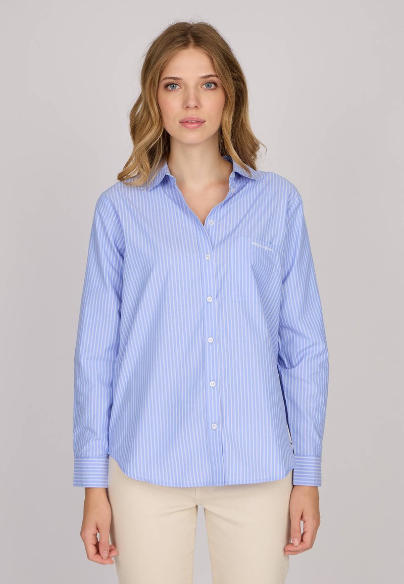 Chemise boutonnée à rayures bleu clair en tissu à texture lisse, avec un col et des manches longues, comportant une poche sur la poitrine gauche.