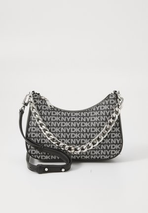 Black and white DKNY shoulder bag with logo pattern, silver chain and leather straps, curved shape, textured fabric, and zipper closure.