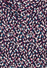 Top a maniche corte con scollatura a V, realizzato in tessuto morbido con uno sfondo viola e un motivo astratto colorato in rosa, bianco e blu.