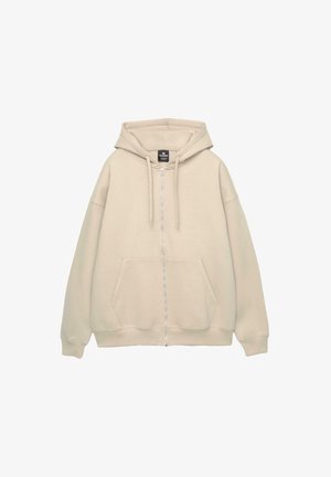 Beige zip-up hoodie met een ruime vozak pocket, een verstelbare capuchon en geribde mouwen. Gemaakt van zachte stof met een gladde textuur.