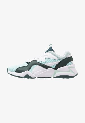 Chaussures de sport turquoise et blanches avec tige en mesh, superpositions synthétiques, col rembourré et semelle extérieure en caoutchouc présentant un motif ondulé.