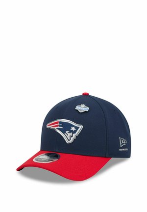 Navy blue and red baseball cap featuring the New England Patriots logo and an NFL Draft 2021 pin on the front panel.