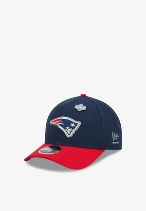 Navy blue and red baseball cap featuring the New England Patriots logo and an NFL Draft 2021 pin on the front panel.