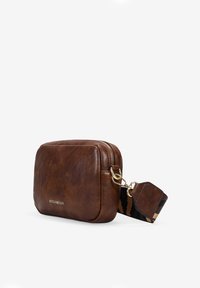 Bolso rectangular de cuero marrón con cierre de cremallera, herrajes dorados y una correa desmontable con patrón. Textura suave, diseño compacto.