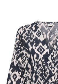 Langarmbluse aus Stoff in Marineblau und Weiß mit tribalem Ikat-Muster; verfügt über einen V-Ausschnitt und eine durchgehende Knopfleiste.