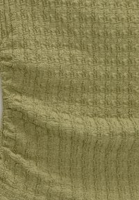 Tissu texturé couleur vert olive doux, présentant un design froissé avec des motifs répétés subtils, créant de la profondeur et un intérêt visuel.