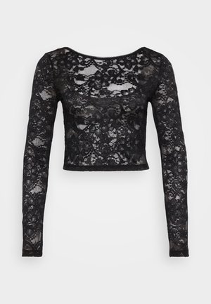 Haut court en dentelle noire avec des manches longues, présentant un motif floral et une texture translucide. Encolure arrondie et design ajusté.