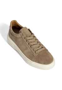 Beiger Wildledersneaker mit beigen Schnürsenkeln und weißer Gummisohle, leicht geneigt, um die Oberseite und die Außenseite zu zeigen.