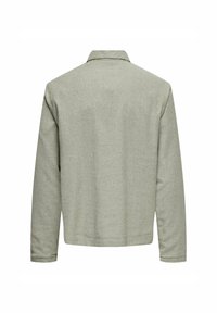 Grüne, strukturierte Jacke mit Kragen und langen Ärmeln. Die Rückansicht zeigt ein einfaches Design ohne sichtbare Verschlüsse oder Muster.