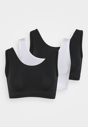 Three seamless crop tops in black and white, featuring wide straps, a scooped neckline, and soft, stretchy fabric.