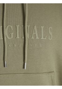 Groene sweatshirt met een textuurstof, voorzak, koordjes met metalen uiteinden en reliëfletters die "ORIGINALS JACK & JONES" zeggen.