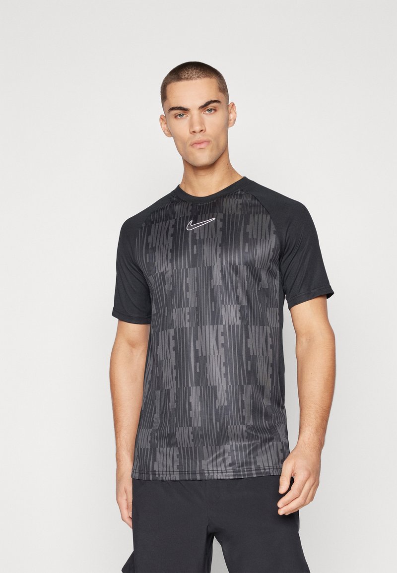 Camiseta atlética negra de manga corta, con un patrón texturizado del nombre de la marca. Incluye un logo blanco en el pecho.
