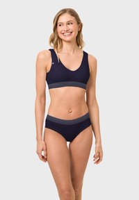 Dunkelblauer Badeanzug bestehend aus einem sportlichen Bralette mit Streifen am Bund und passenden hochgeschnittenen Bikinihosen mit glatter Textur.