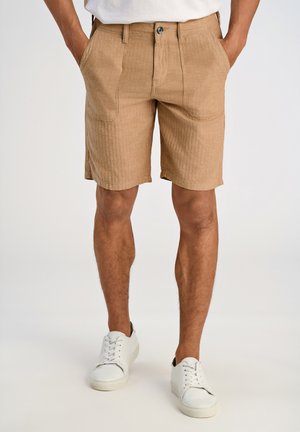 Khaki brune shorts i et struktureret stof, med lommer, en knaplukning og en lige pasform, parret med hvide sneakers.