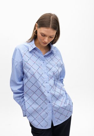Blue button-up shirt featuring striped and diamond-patterned fabric with colorful embroidery accents. Soft texture and relaxed fit.
