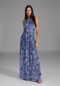 Vestido maxi en tonos azules y morados, con tejido plisado, corpiño ajustado, diseño de cuello halter, con una falda fluida y sutiles acentos de brillo.